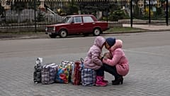 Mãe abraça a filha enquanto esperam pelo autocarro que as levará da cidade de Sloviansk, em Donetsk, Ucrânia