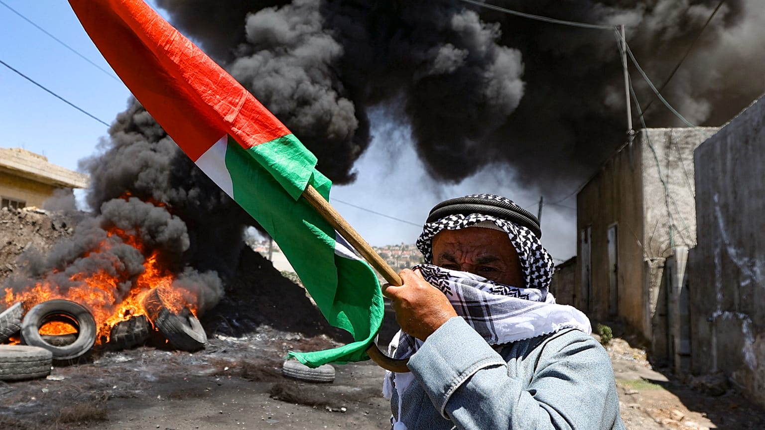 رجل فلسطيني مسن يحمل العلم الوطني في أعقاب مظاهرة ضد مصادرة إسرائيل للأراضي الفلسطينية في قرية كفر قدوم. 2022/07/01