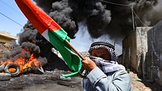 رجل فلسطيني مسن يحمل العلم الوطني في أعقاب مظاهرة ضد مصادرة إسرائيل للأراضي الفلسطينية في قرية كفر قدوم. 2022/07/01
