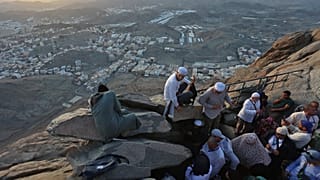بعض الحجاج يجلسون في أعلى جبل النور المطل على مدينة مكة المكرمة