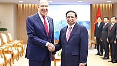 Russian Foreign Minister Sergey Lavrov and Vietnamese Prime Minister Pham Minh Chinh shake hands in Hanoi, Vietnam