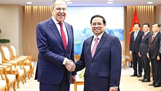 Russian Foreign Minister Sergey Lavrov and Vietnamese Prime Minister Pham Minh Chinh shake hands in Hanoi, Vietnam
