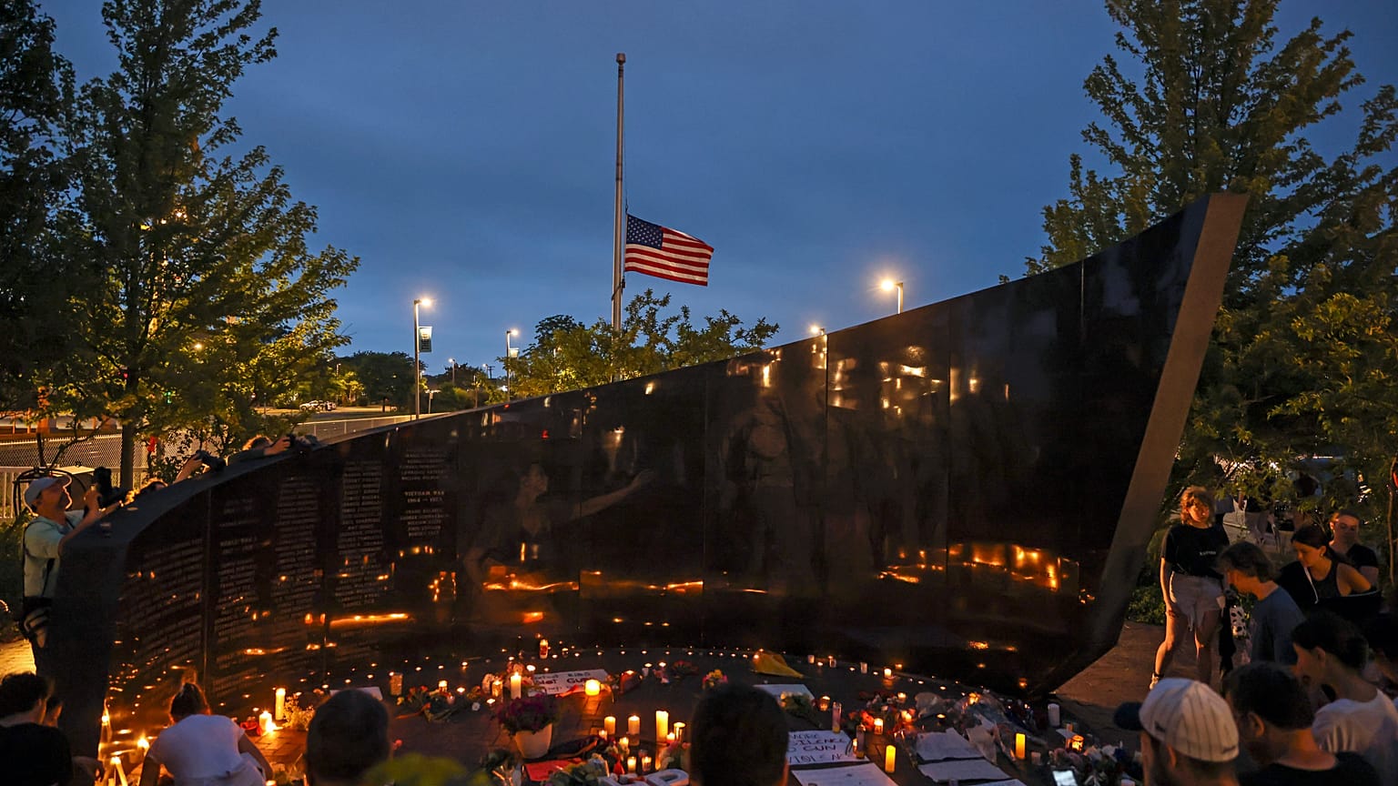 Dozens of mourners gather for a vigil in downtown Highland Park.