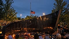 Dozens of mourners gather for a vigil in downtown Highland Park.