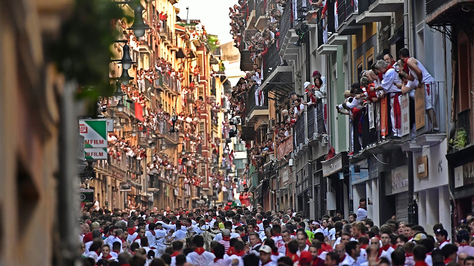 La gente corre por las calles delante de los toros de lidia durante el primer día de los encierros de las fiestas de San Fermín en Pamplona, el jueves 7 de julio de 2022