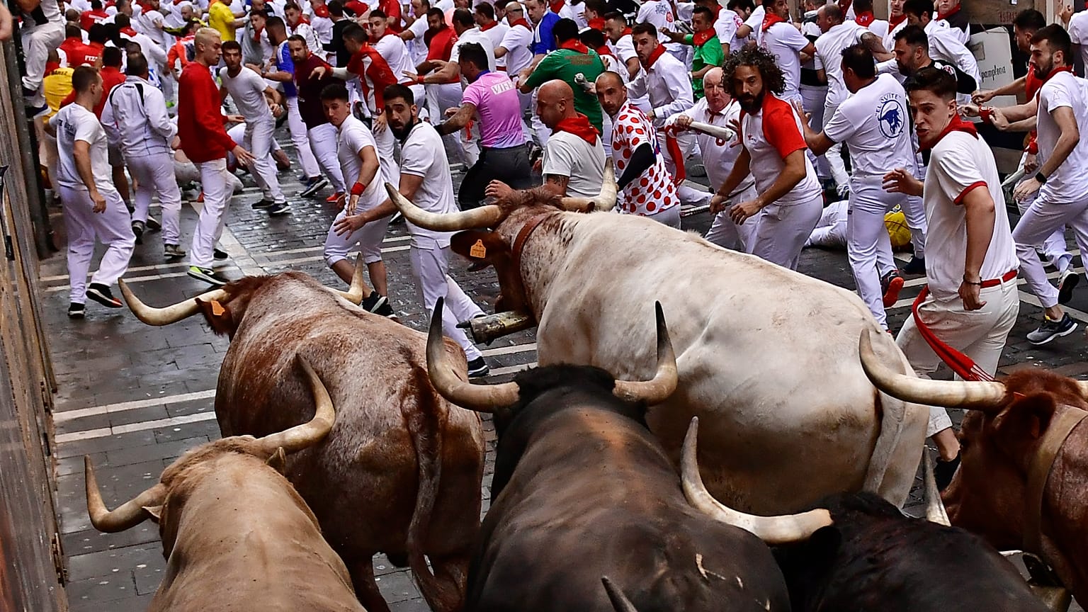 Carreras por las calles con toros y novillos de lidia durante el primer día de los encierros de las fiestas de San Fermín en Pamplona, norte de España, el 7 de julio de 2022