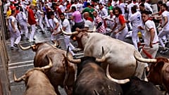 Carreras por las calles con toros y novillos de lidia durante el primer día de los encierros de las fiestas de San Fermín en Pamplona, norte de España, el 7 de julio de 2022