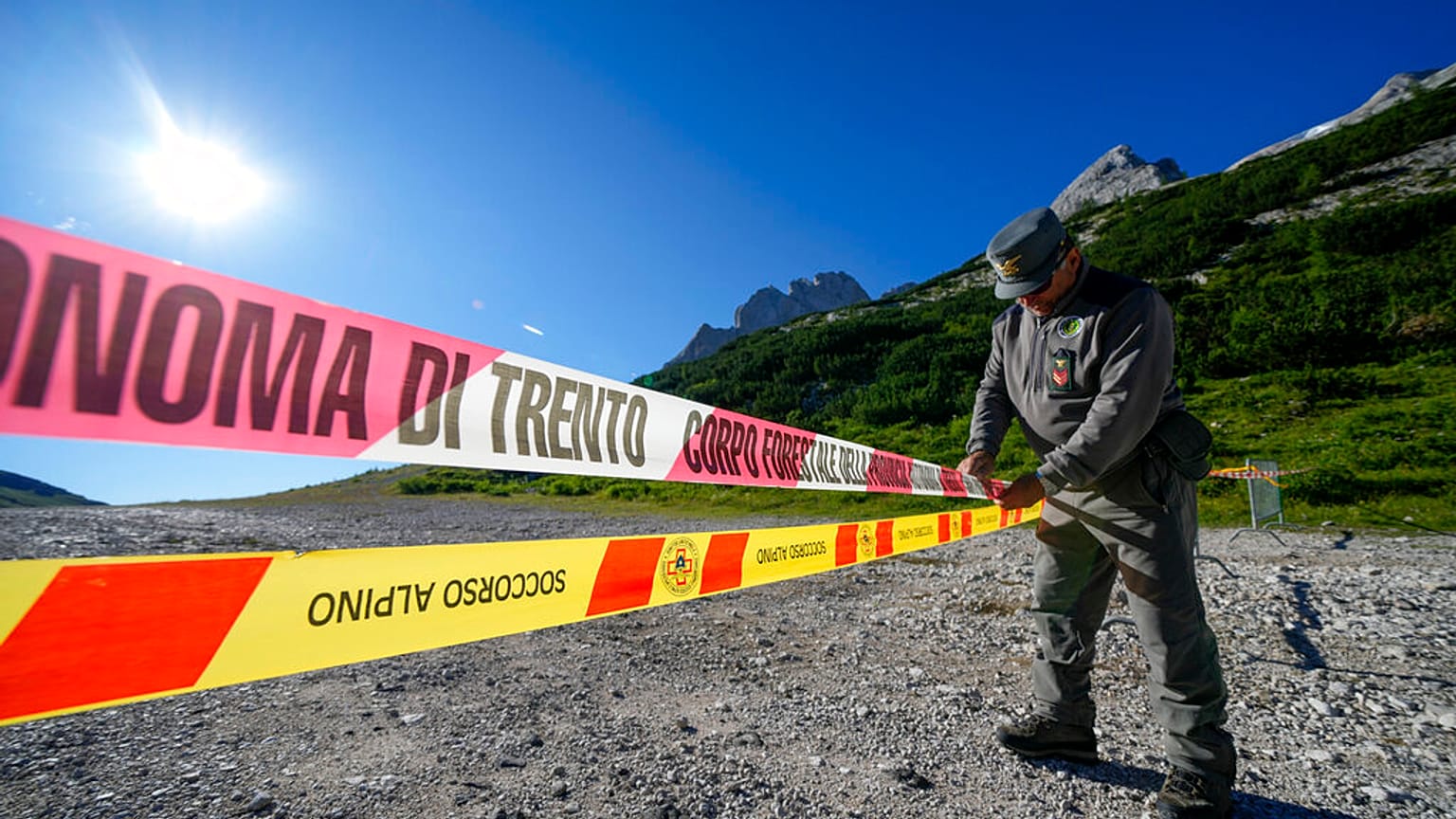 Un policier bloque l'accès au glacier de la Marmolada, dans les Alpes italiennes, dans le nord de l'Italie, mercredi 6 juillet 2022. 