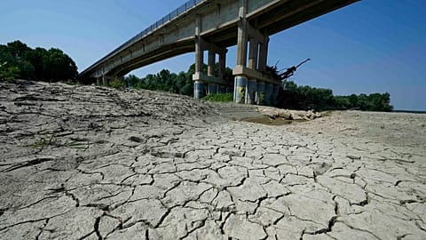 Dry cracked land visible under a bridge in Boretto on the bed of the Po river, Italy, Wednesday, June 15, 2022.