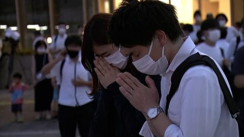 People lay flowers pay respects at Abe murder scene