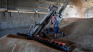 A farmer collects harvest from his field near the front line in the Dnipropetrovsk region, Ukraine, July 4, 2022.