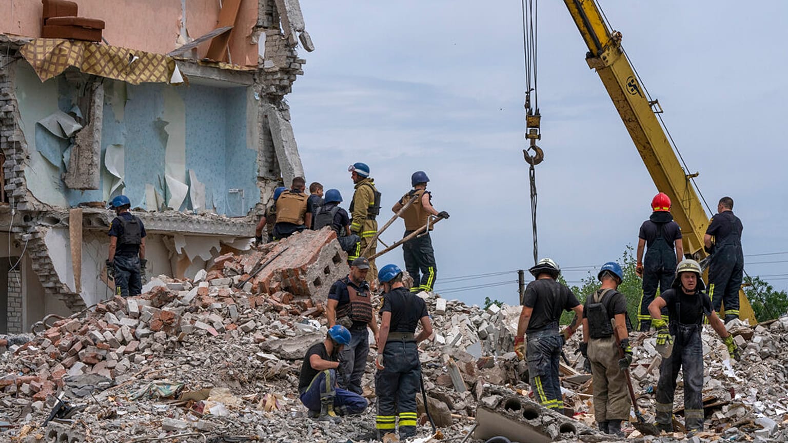 Des secouristes passent au crible les décombres après le bombardement d'un immeuble à Tchassiv Yar (Donbass), le 10 juillet 2022. 