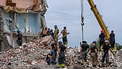 Des secouristes passent au crible les décombres après le bombardement d'un immeuble à Tchassiv Yar (Donbass), le 10 juillet 2022. 