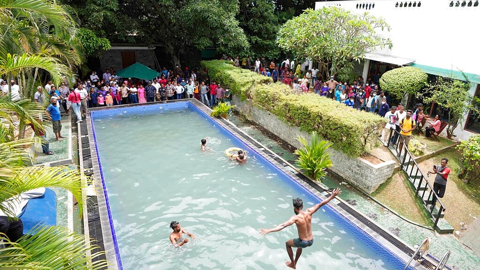 Srilanqueses se bañan en la piscina de la residencia presidencial