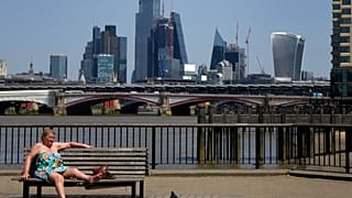 Eine Frau sonnt sich an der Themse in London. 