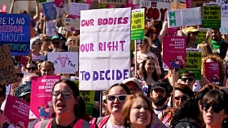 Demonstrators hold placards as they attend a march in support of the Abortion Rights group, in London.