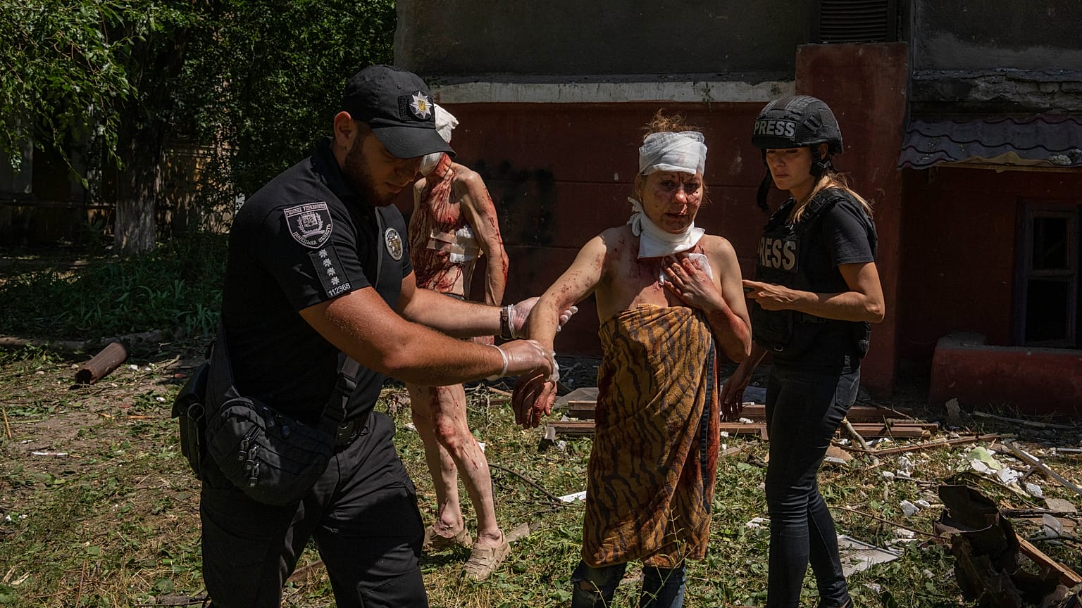Un policier aide une femme blessée après la frappe d'un missile sur une zone résidentielle à Kramatorsk, dans la région de Donetsk (Ukraine), jeudi 7 juillet 2022.