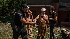 Un policier aide une femme blessée après la frappe d'un missile sur une zone résidentielle à Kramatorsk, dans la région de Donetsk (Ukraine), jeudi 7 juillet 2022.