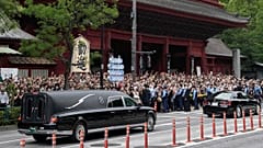 The vehicle, left, carrying the body of former Japanese Prime Minister Shinzo Abe.