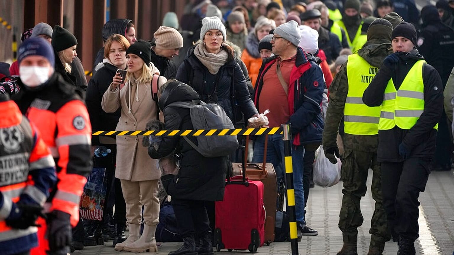 Displaced Ukrainians stand in a line on the train platform after arriving from Ukraine at the station in Przemysl, Poland, Thursday, March 3, 2022. 