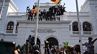 Demonstrators shout slogans and wave Sri Lankan flags during an anti-government protest inside the office building of Sri Lanka's prime minister in Colombo.