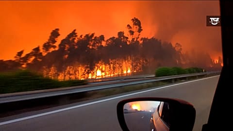 Wide of fire seen on the A1 highway. Journalist of TSF Radio Noticias, Rui Tukayana, filming, driving and explaining what he sees.