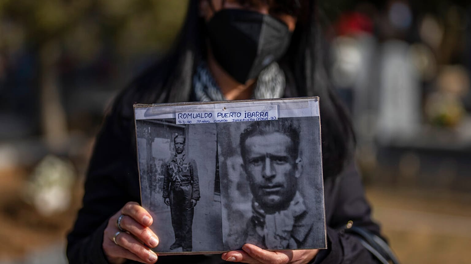 Un familiar de Romualdo Puerto Ibarra, asesinado durante la Guerra Civil española,  muestra su fotografía. Cementerio de Guadalajara, España, 12/2/2022