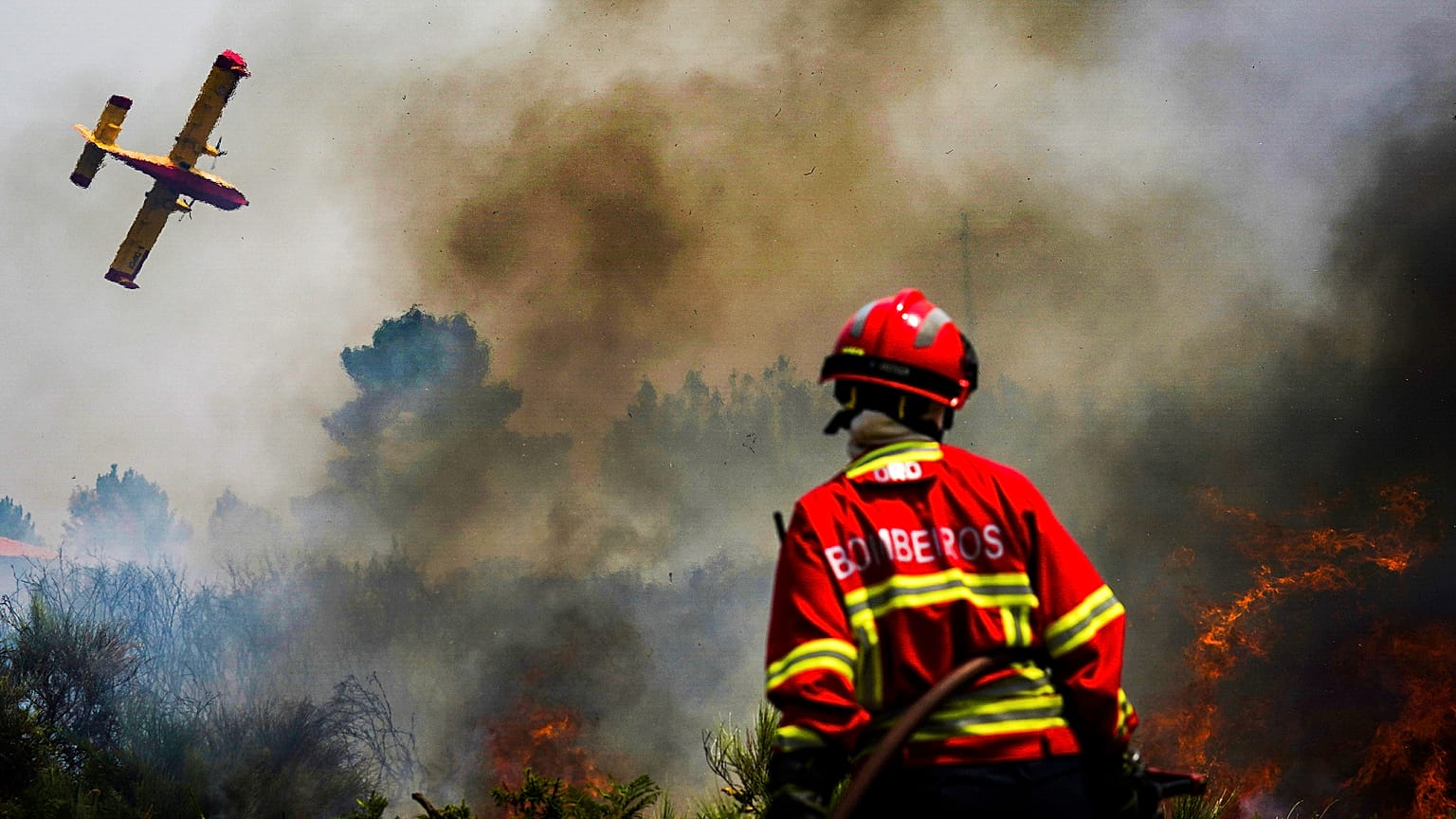 Bombeiro observa avião no combate ao incêndio em Baião, norte de Portugal