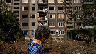 Une femme passe devant un bâtiment endommagé à la suite d'une frappe de missile à Konstantinovka, dans l'Oblast de Donetsk, dans l'est de l'Ukraine, vendredi 15 juillet 2022. 