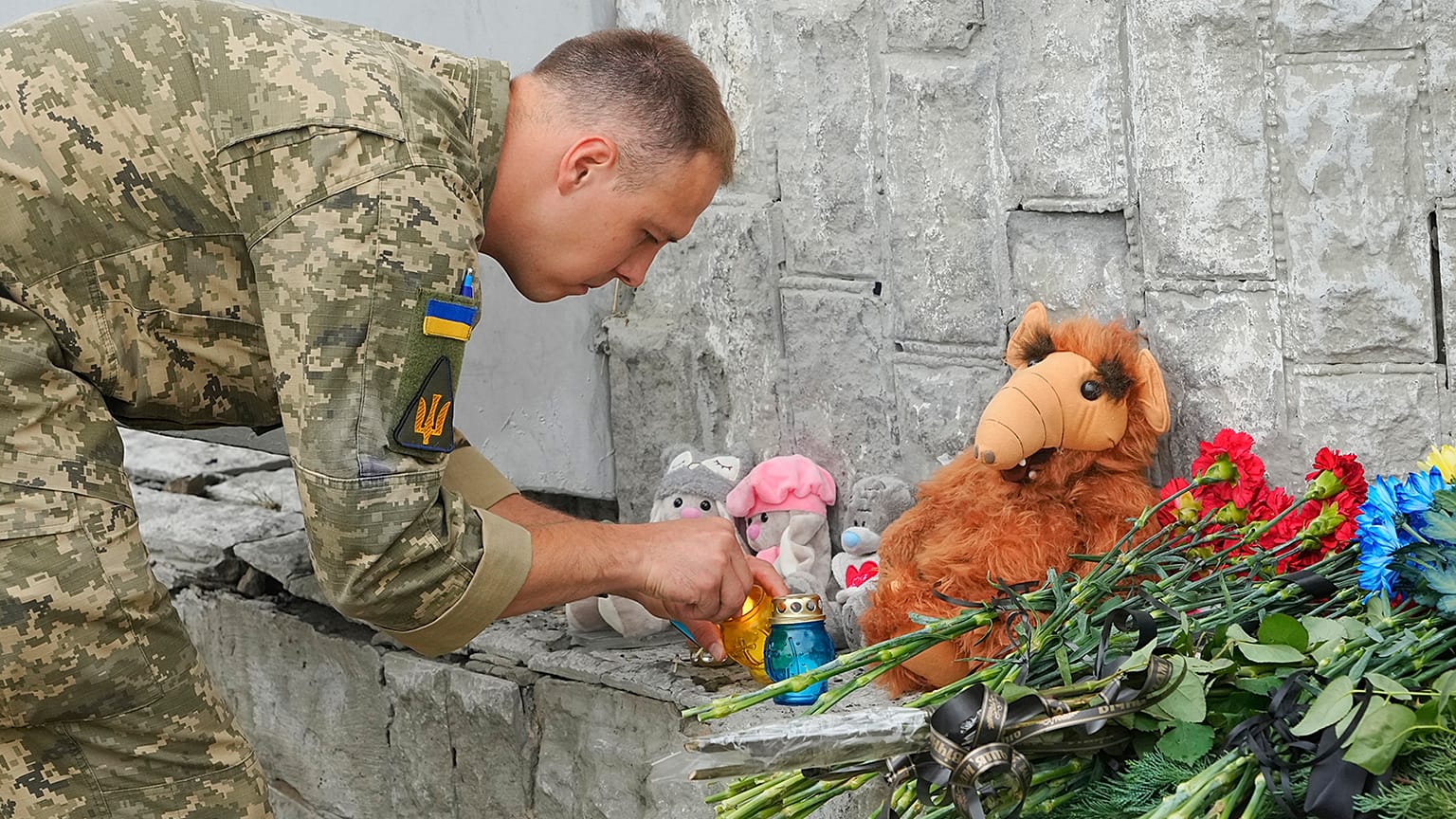 Ukrainian serviceman lights a candle at the site of a Russian shelling on Thursday, in Vinnytsia, 15 July 2022