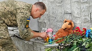 Ukrainian serviceman lights a candle at the site of a Russian shelling on Thursday, in Vinnytsia, 15 July 2022
