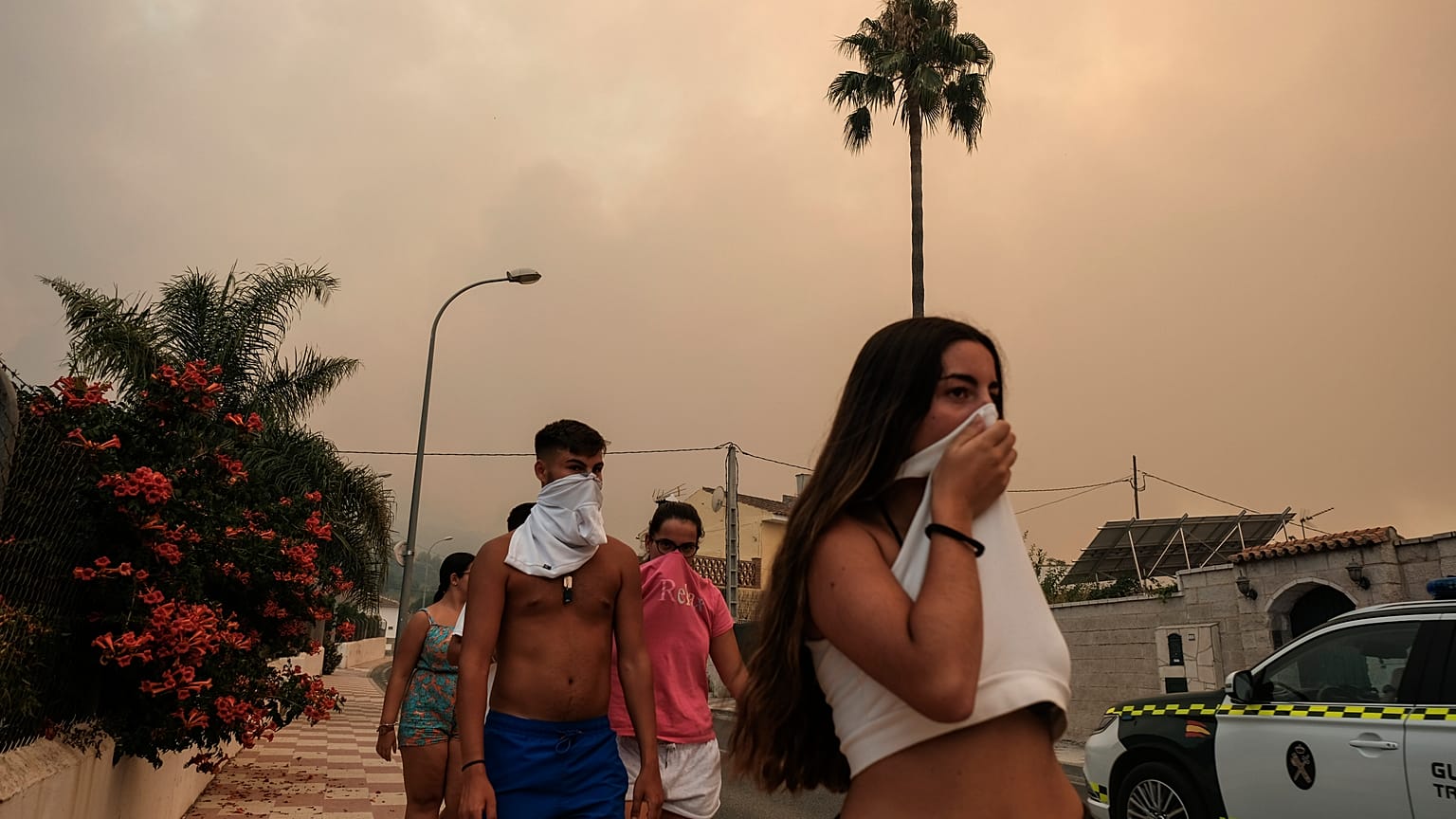 Los residentes se protegen del humo mientras un incendio forestal avanza cerca de una zona residencial en Alhaurín de la Torre, Málaga, España, el 16 de julio de 2022.