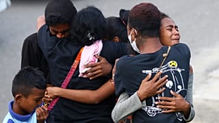 Familiares de luto pela morte de 10 pessoas numa emboscada na província indonésia de Papua