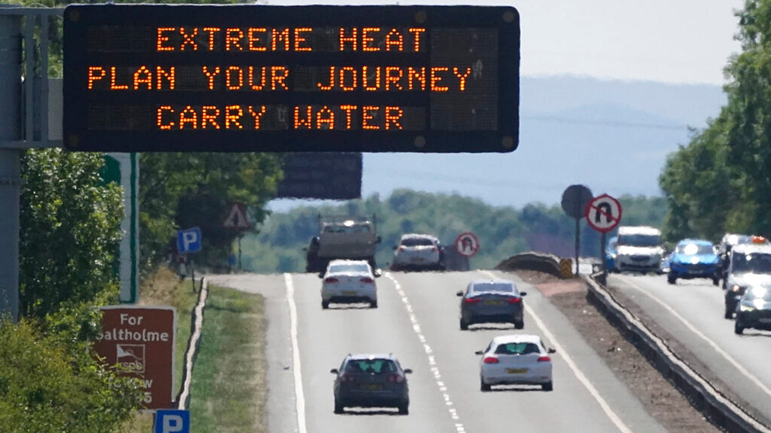 A matrix sign over the A19 road towards Teesside displays an extreme weather advisory as the UK braces for the upcoming heatwave, in England, Saturday July 16, 2022.