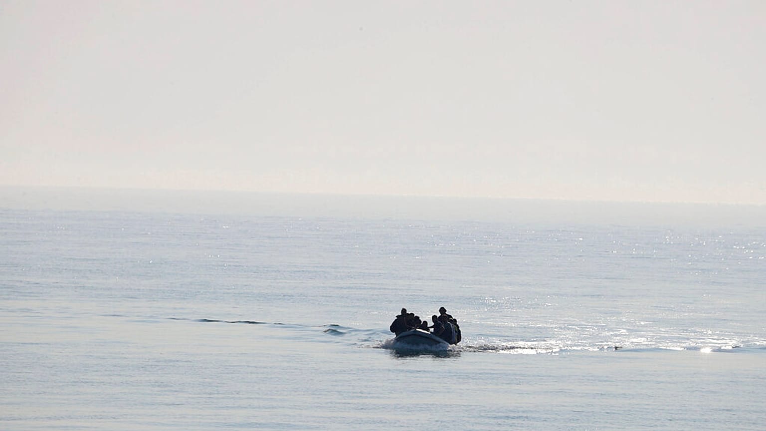 FILE - A group of people thought to be migrants arrive in an inflatable boat at Kingsdown beach after crossing the English Channel, near Dover, Kent, England, 2020. 