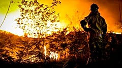 Un bombero se encuentra junto a un incendio forestal cerca de Landiras, en el suroeste de Francia, el lunes por la mañana, 18 de julio de 2022.
