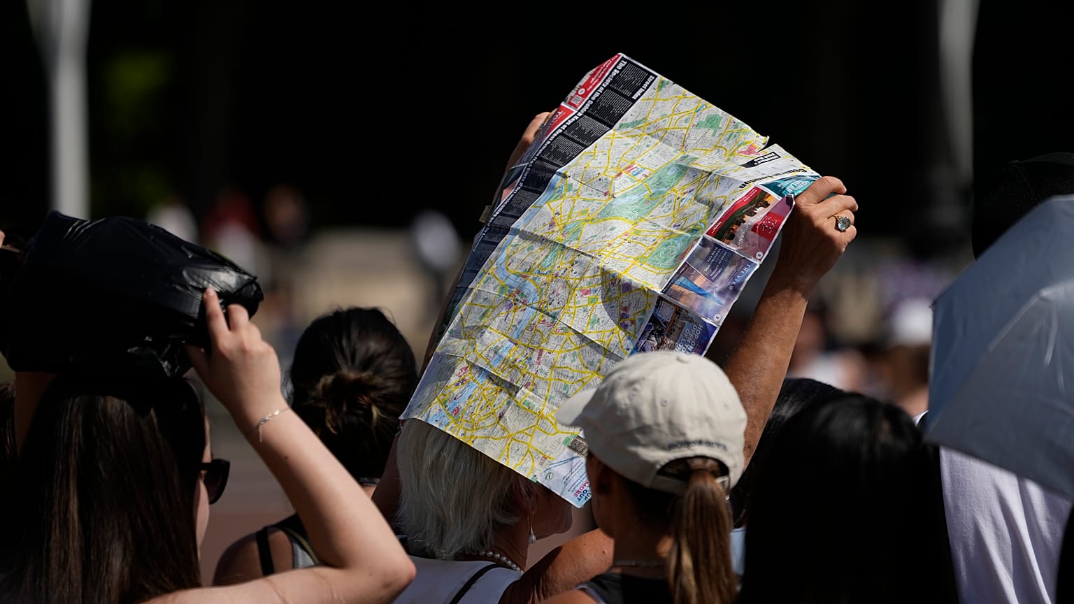 Touristen suchen unter einem Londoner Stadtplan Schatten
