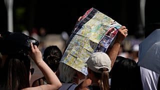 Touristen suchen unter einem Londoner Stadtplan Schatten