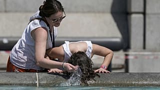 A person wets their hair in a fountain at Trafalgar Square in central London, Tuesday July 19, 2022.