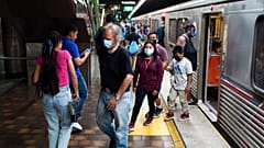 Des usagers masqués et non masqués sont vus dans une station de métro à Los Angeles, mercredi 13 juillet 2022. 