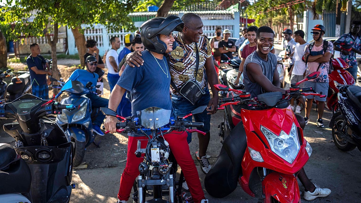 People gather on their electric scooters to spend the late afternoon showing off stunts and racing in Havana, Cuba, Friday, July 15, 2022. 