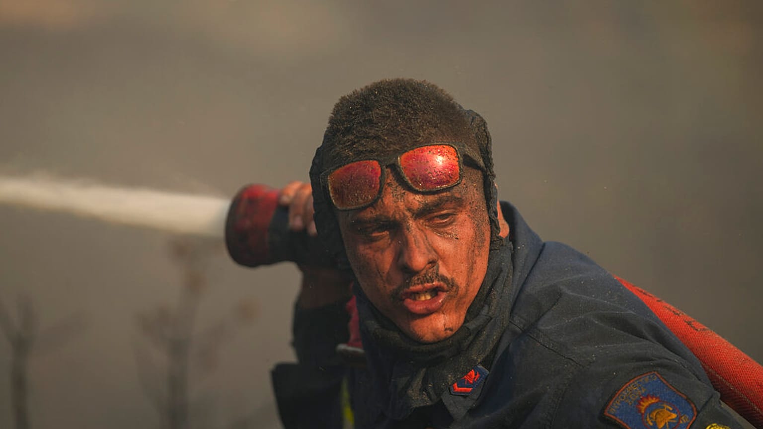 Bombeiro combate incêndio a poucos quilómetros de Atenas, Grécia.