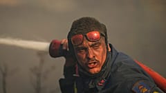 Bombeiro combate incêndio a poucos quilómetros de Atenas, Grécia.