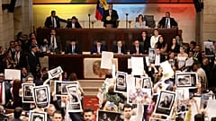 Legisladores sostienen fotos de personas desaparecidas durante el conflicto interno de Colombia en el Congreso en Bogotá, Colombia, el miércoles 20 de julio de 2022.