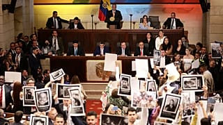 Legisladores sostienen fotos de personas desaparecidas durante el conflicto interno de Colombia en el Congreso en Bogotá, Colombia, el miércoles 20 de julio de 2022.