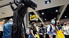 Des visiteurs de la convention observent une réplique taille réelle d'un monstre de la série de films  "Alien".