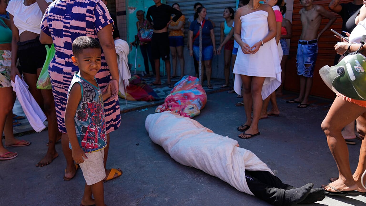 A favela lakói körbecsavart testet állnak körbe a razzia után 