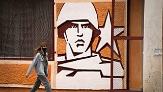 A woman walks past the Operational Group of Russian Forces HQ in Tiraspol, the capital of the breakaway region of Transnistria, in Moldova, Monday, Nov. 1, 2021.
