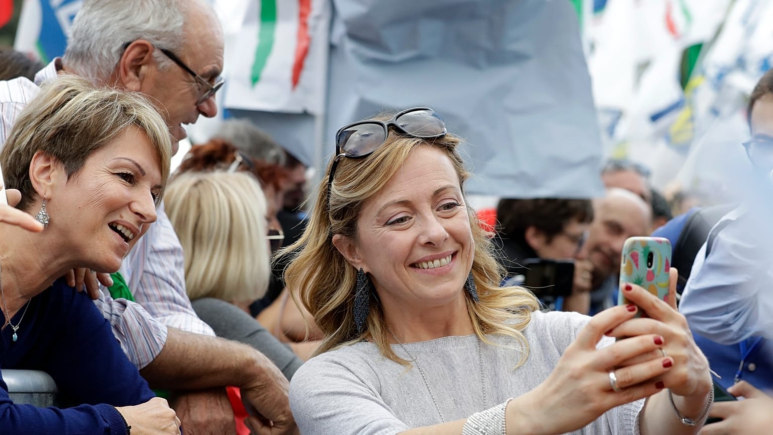 Aşırı sağcı İtalya'nın Kardeşleri Partisi (FdI) lideri Giorgia Meloni, taraftarlarıyla selfie çekerken. (Meloni, cep telefonuyla kendisi fotoğraf çekiyor)