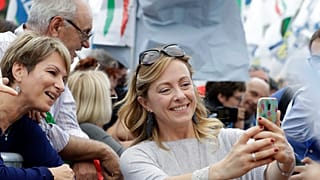 Aşırı sağcı İtalya'nın Kardeşleri Partisi (FdI) lideri Giorgia Meloni, taraftarlarıyla selfie çekerken. (Meloni, cep telefonuyla kendisi fotoğraf çekiyor)